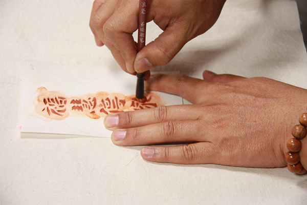 步驟1-1：胚布型染 ▲ 先將模板置於水洗棉質胚布上，均勻地用毛筆轉刷上手繪專用顏料。